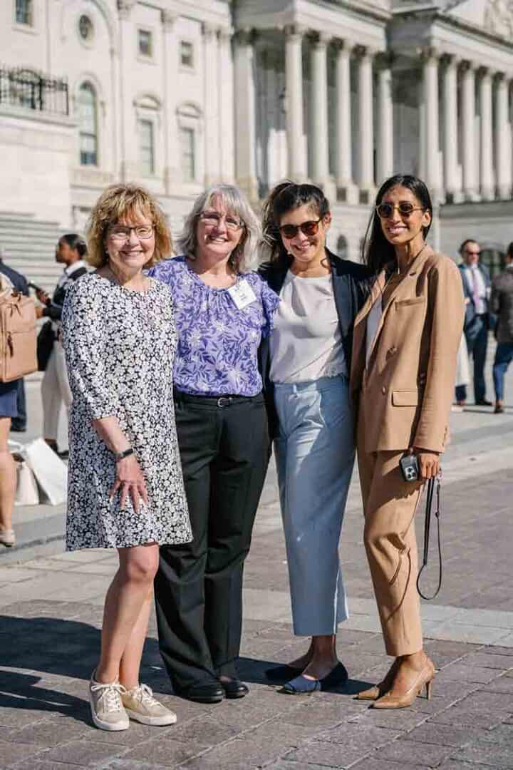 Allergy & Asthma Day Capitol Hill 2025: Leading the Charge Amid Federal Policy Shifts 12 Four women stand together smiling in front of a grand, white government building with columns. They are dressed in business casual and professional attire, and the scene is outdoors on a sunny day.