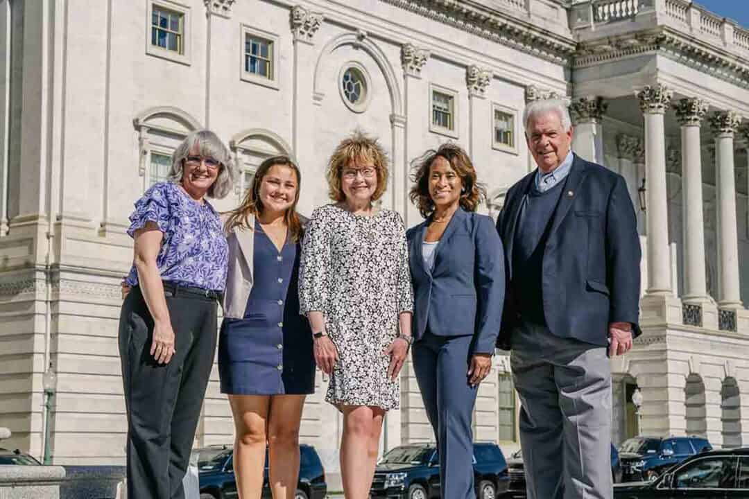 Allergy & Asthma Day Capitol Hill 2025: Leading the Charge Amid Federal Policy Shifts 3 Five adults stand smiling in business attire in front of a large, white government building with columns and arched windows on a sunny day.