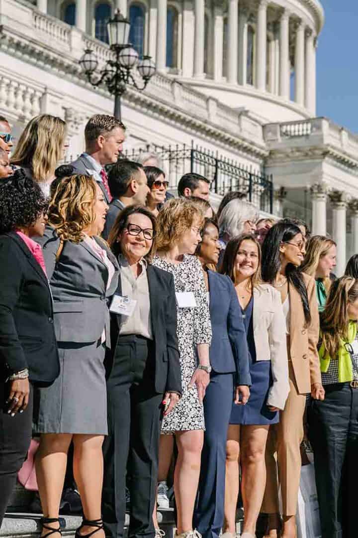 Allergy & Asthma Day Capitol Hill 2025: Leading the Charge Amid Federal Policy Shifts 2 A diverse group of professionally dressed people stand together on the steps outside a large government building with columns, smiling and looking toward the camera.