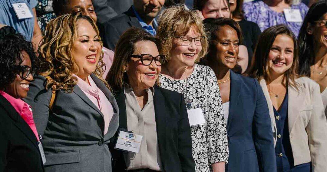 Allergy & Asthma Day Capitol Hill 2025: Leading the Charge Amid Federal Policy Shifts 6 A diverse group of professionally dressed women stand closely together, smiling outdoors at what appears to be a conference or business event, with name badges visible on some of them.