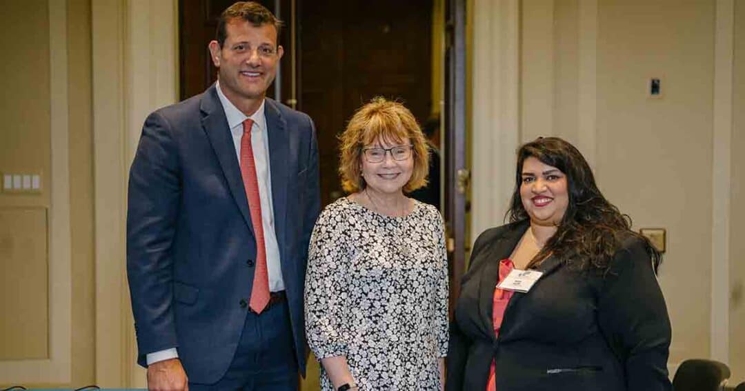 Allergy & Asthma Day Capitol Hill 2025: Leading the Charge Amid Federal Policy Shifts 59 Three people pose indoors, dressed in business attire. The man on the left wears a suit and red tie, the woman in the middle wears glasses and a floral blouse, and the woman on the right wears a black blazer and red top.