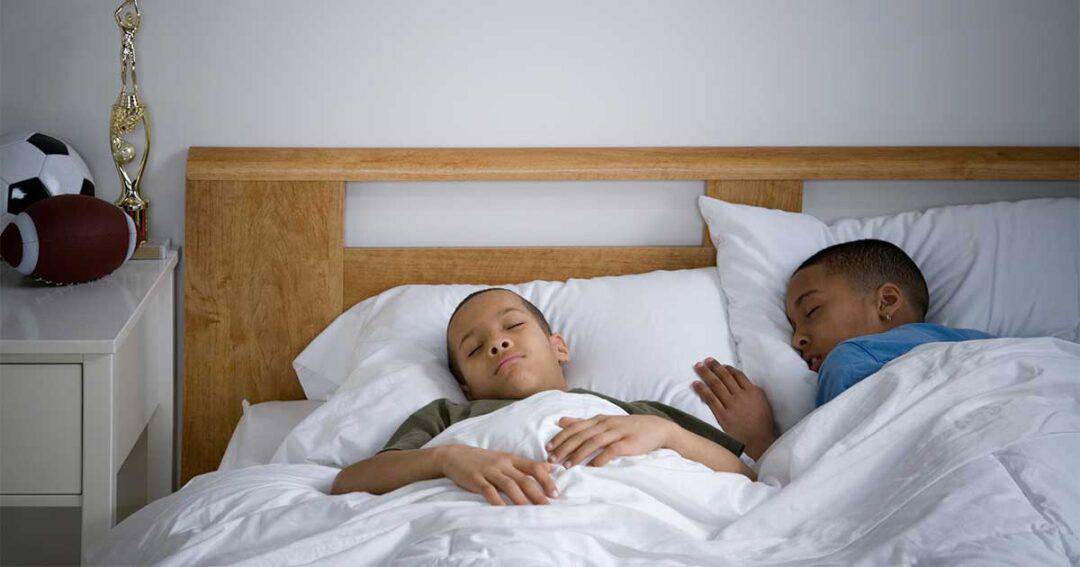 Two tween boys sleeping in the morning after being up all night with asthma issues.