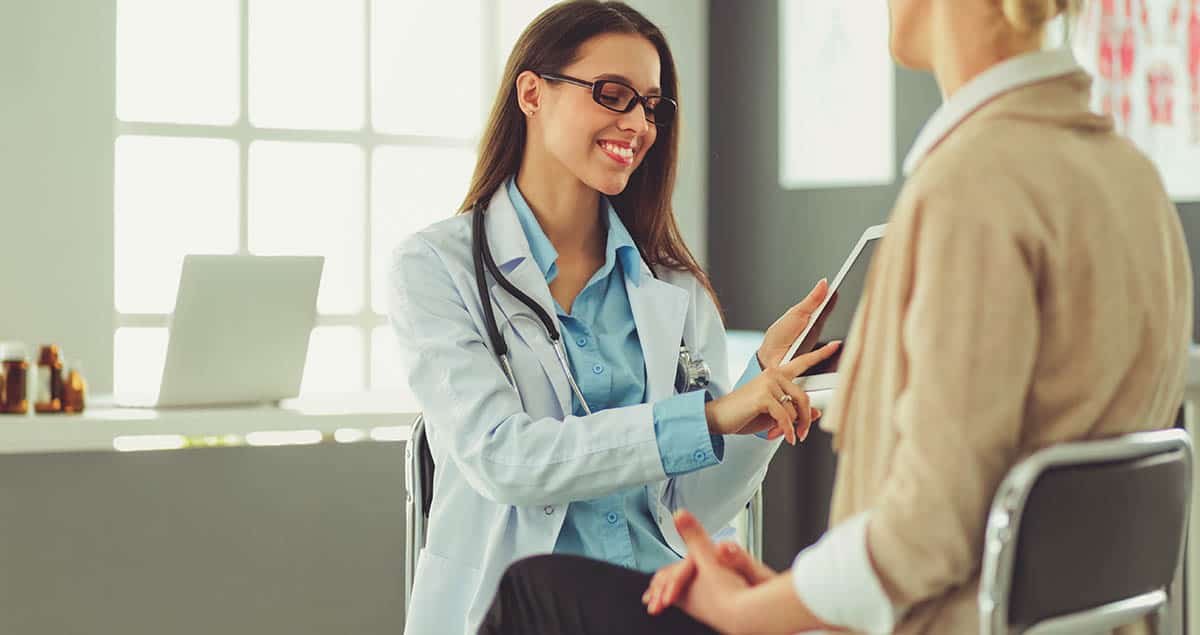 Doctor and patient discussing something while sitting at the table . Medicine and health care concept.