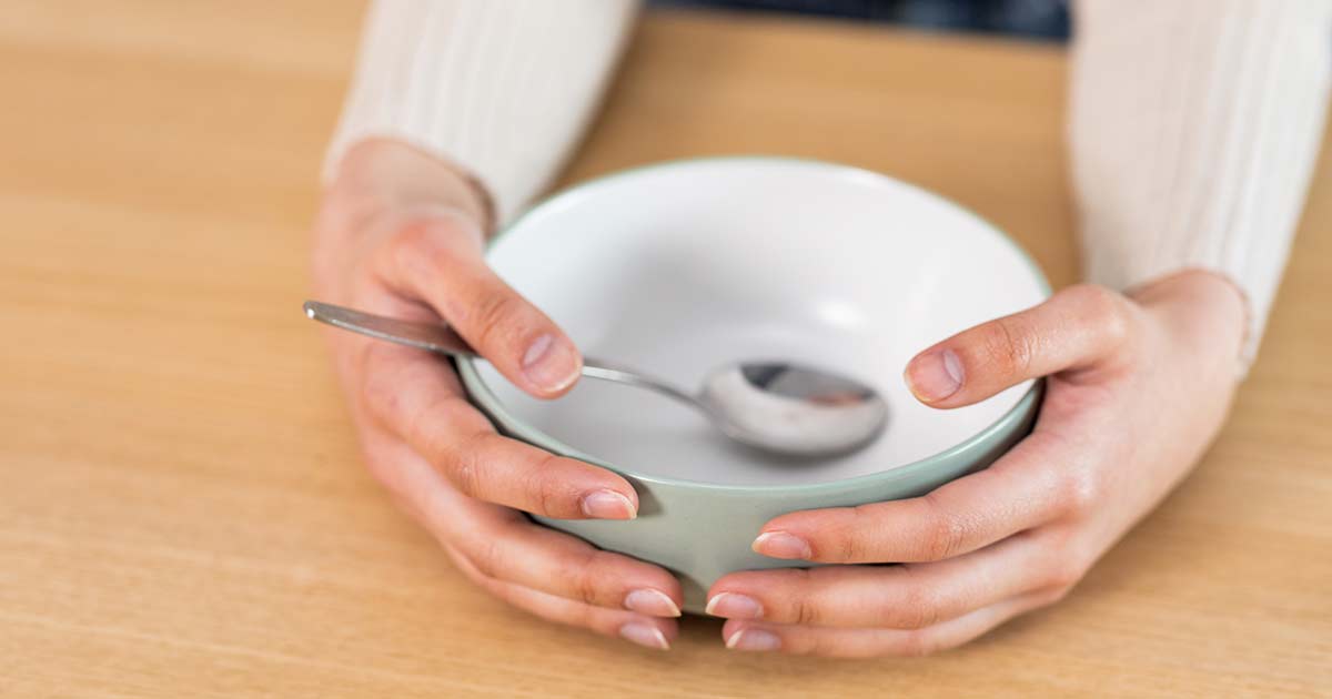 Food Allergies and Food Insecurity in America 10 a woman holding an empty bowl with a spoon