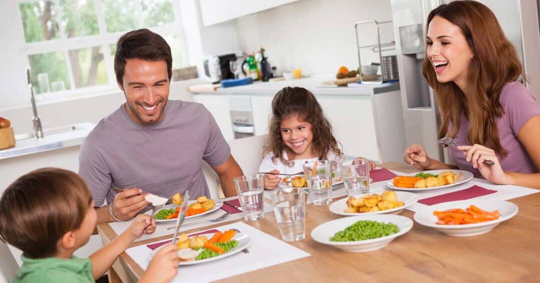 Family sitting at their kitchen table having an allergen friendly dinner.