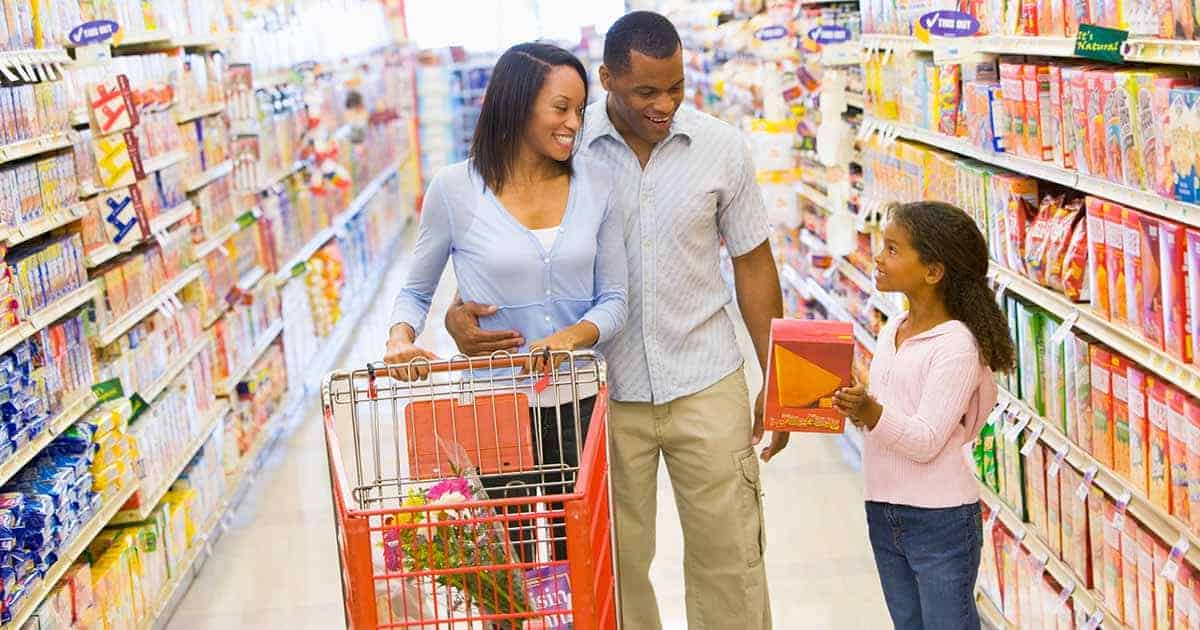 What Can You Do If You Can’t Afford Allergen-Free Foods? 1 Family shopping in the grocery aisle looking for affordable allergen-free foods.