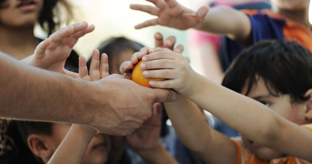 Food Allergies and Food Insecurity in America 9 many hungry children's hands reaching for one orange