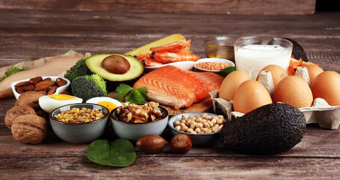 Various foods that are considered high allergic foods on a wooden table. For example: nuts, fish, dairy, eggs.