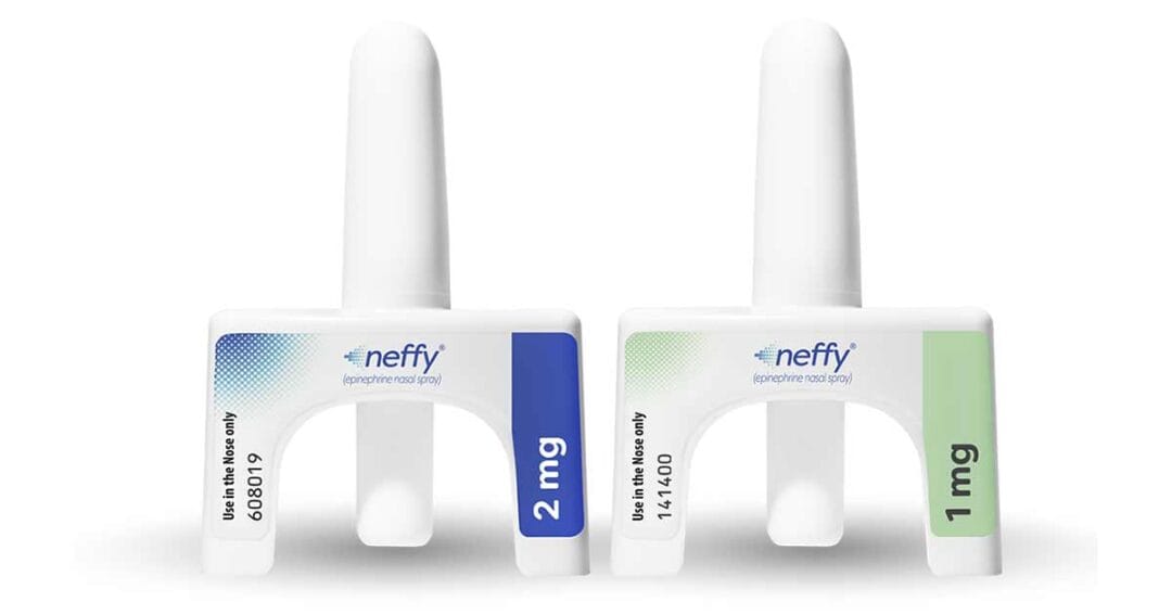 Two neffy epinephrine nasal sprays are shown upright. The left device has a blue label with &ldquo;2 mg,&rdquo; and the right device has a green label with &ldquo;1 mg.&rdquo; Both clearly state &ldquo;Use in the Nose only.&rdquo;.