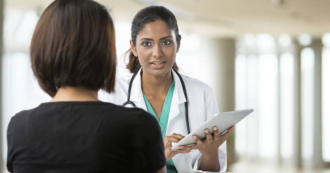 How can Patients and Caregivers Get Involved in Research? 5 Concept image of a patient registering with a caregiver to see if they're eligible for a clinical trial.