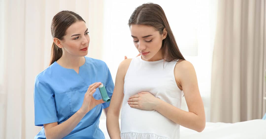 Asthma and Pregnancy 8 Young pregnant woman on hospital bed with doctor showing her how to use her asthma medication.