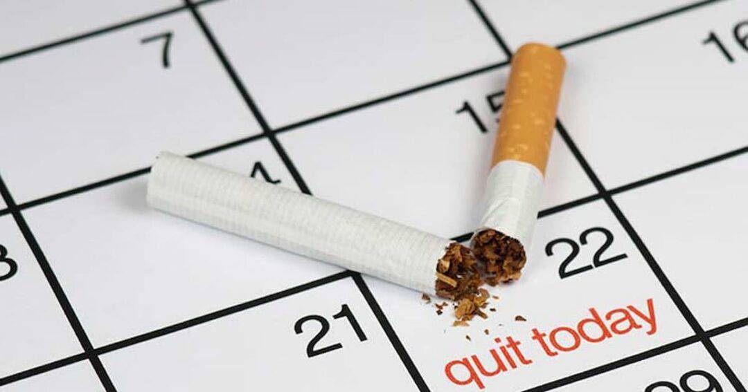 A broken cigarette lies on a calendar page. Tobacco bits are scattered near the cigarette. The phrase "quit today" is printed near the bottom of the calendar, suggesting a focus on quitting smoking.