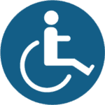 Icon of a person in a wheelchair, represented in white on a blue circular background, symbolizing accessibility.