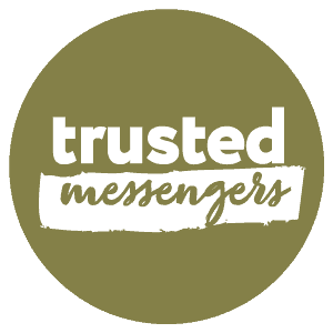 Olive green circle with "trusted messengers" written inside. "Trusted" is in bold white text, and "messengers" is in cursive white text on a paintbrush stroke.