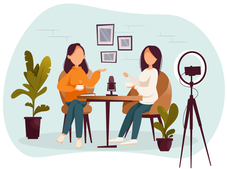 Two women are sitting at a table with coffee cups, recording a podcast or video. A microphone is between them, and a ring light with a smartphone is set up. The background features potted plants and framed pictures on the wall.